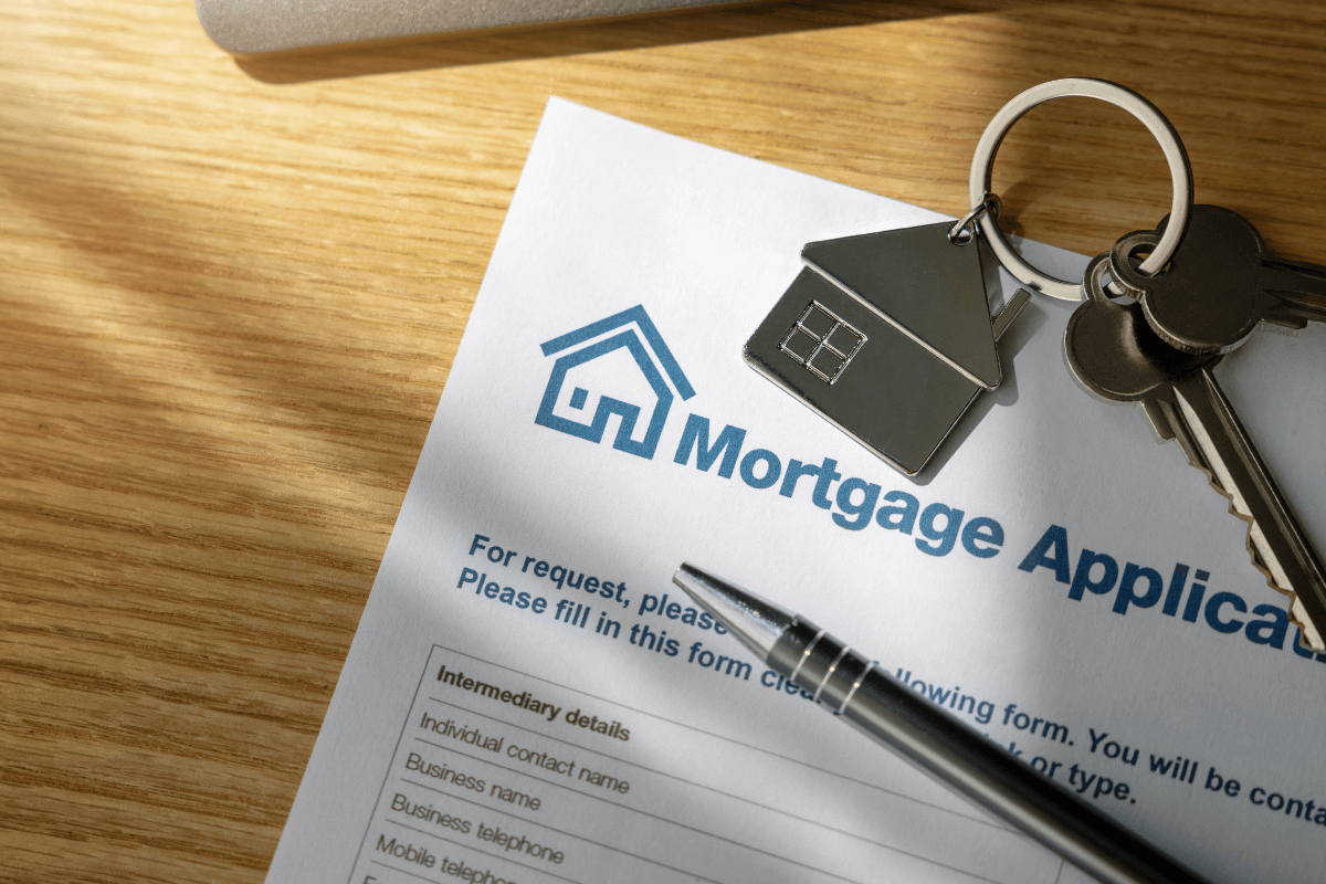 Close up image of an application form with a house keyring and pen on top