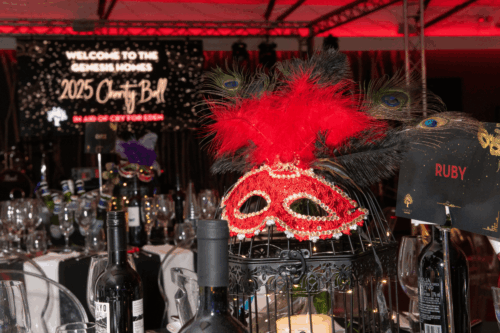 Red sequined mask on black bird cage as table centrepiece for masquerade ball