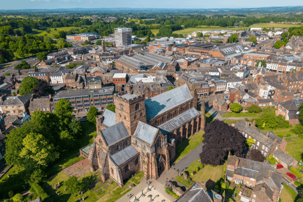 Aerial image of Carlisle showing the cathedral in the foreground and the city spread out towards green countryside beyond